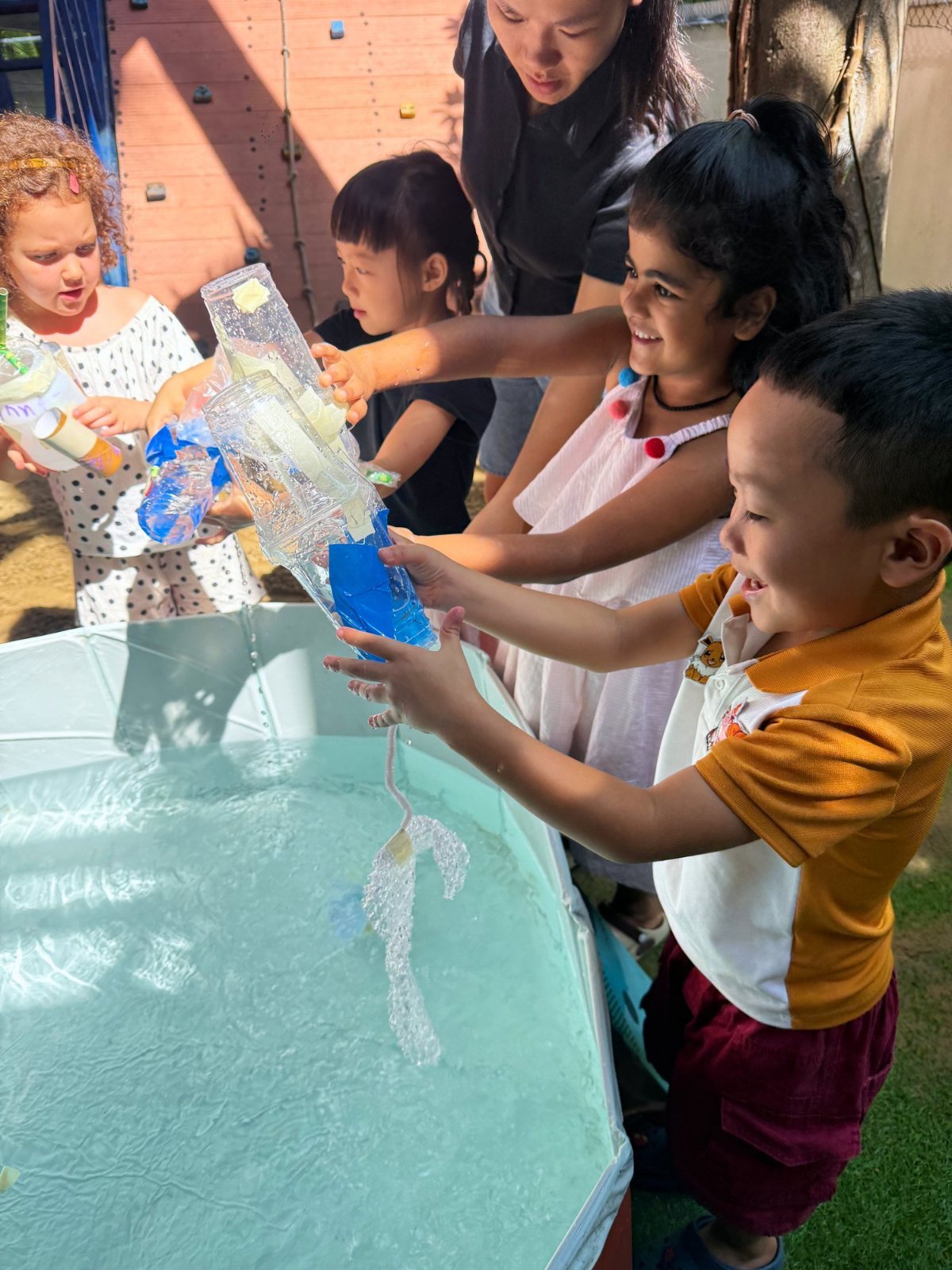 Year 1 students testing their bottle models over a tank of water