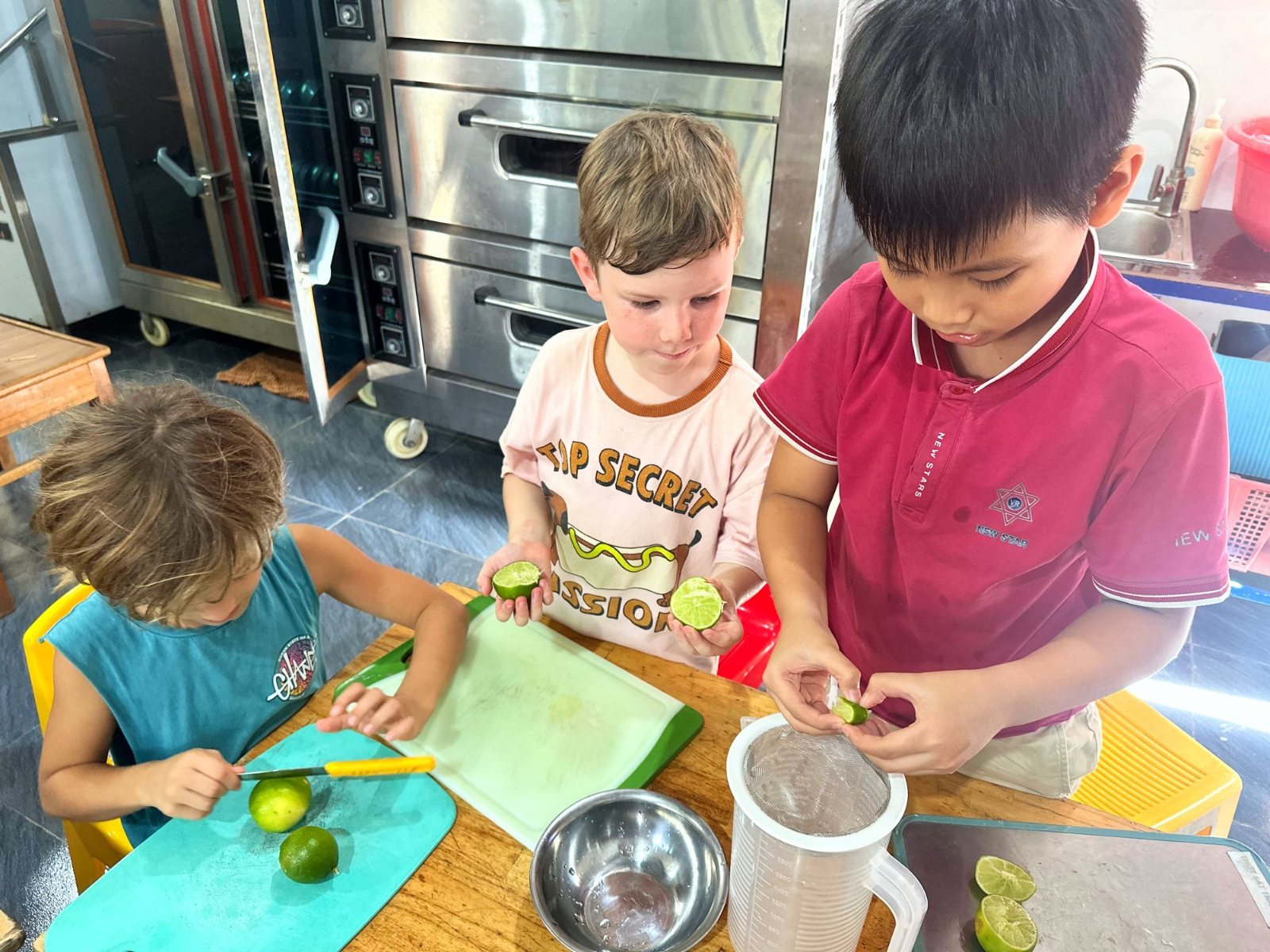 Year 2-3 students cutting limes and squeezing the juice for lemonade