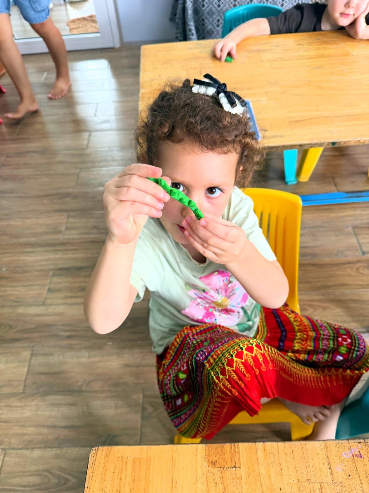 A Year 1 student peering through a bead chain held up to her eye