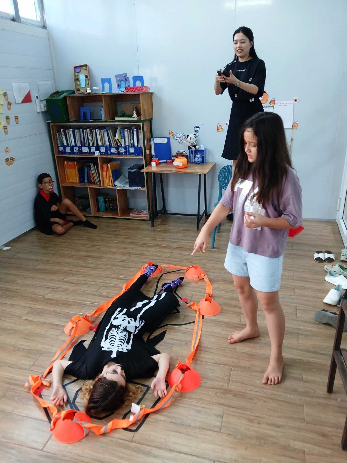 A Year 7 student in a skeleton costume playing the body in the mystery room