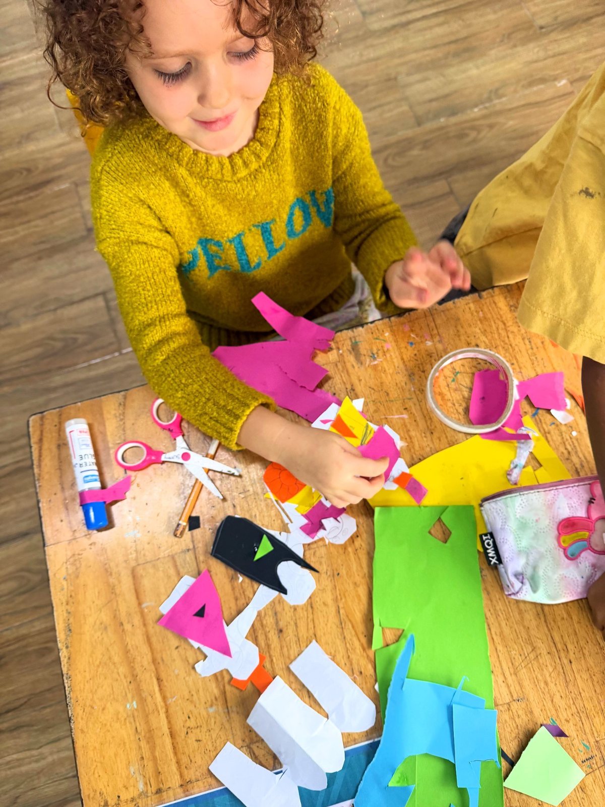 A Year 1 child arranging the paper people she cut out