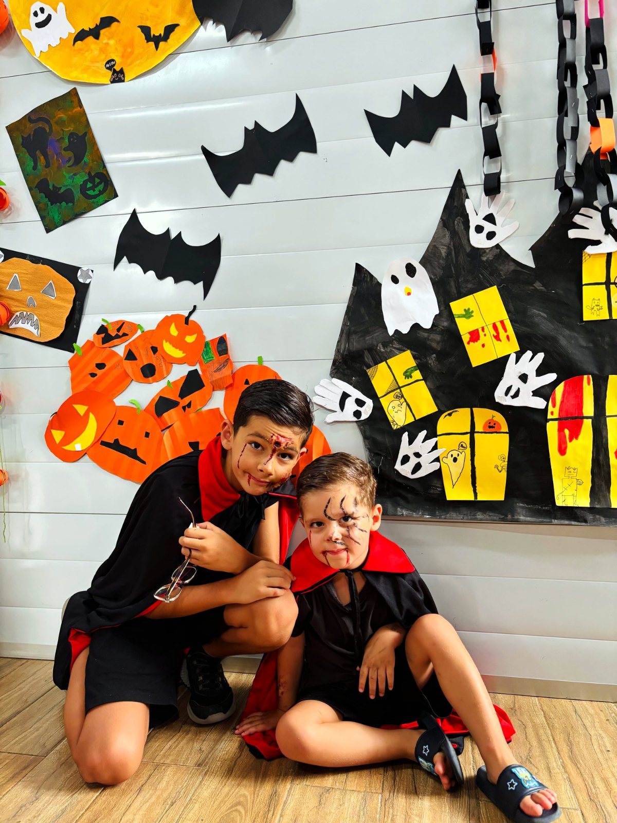 Two children in vampire capes and face paint at the Halloween wall