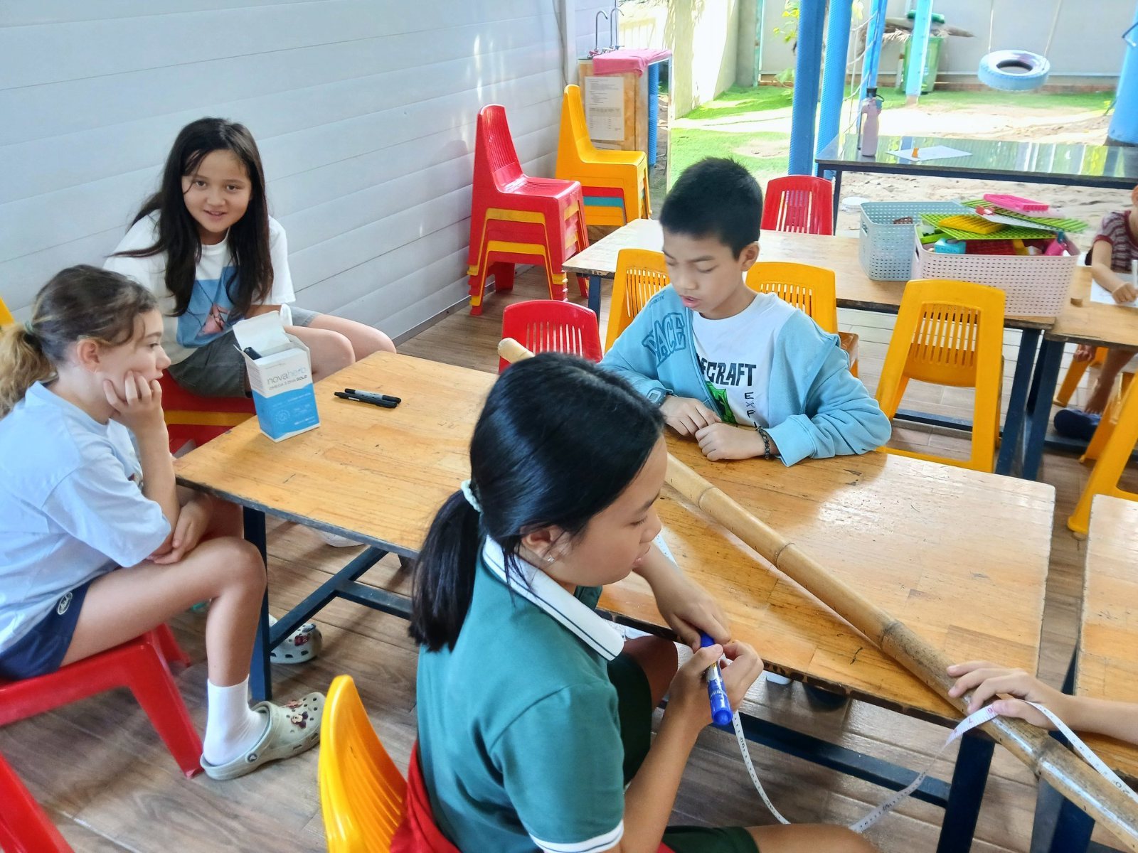 Year 7 students marking a bamboo tide pole against a tape measure